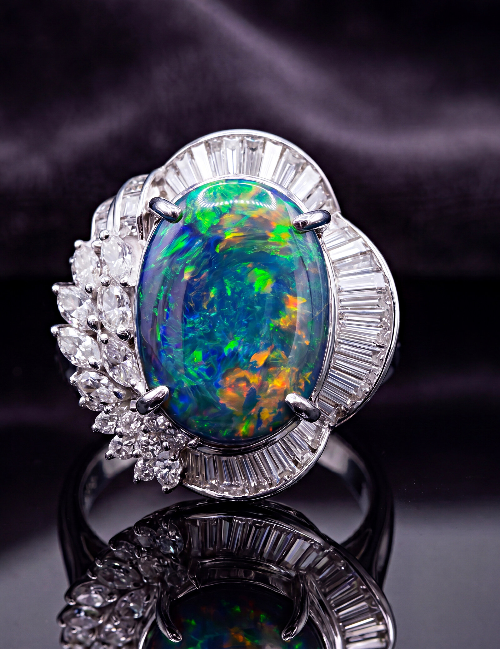 The Aurora — an opal dress ring in platinum, its dark opaque body igniting a play of blue-green fire, set with a baguette-diamond halo and a marquise-and-brilliant diamond cluster